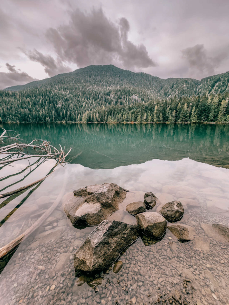 Crystal clear turquoise water and mountain reflections at Cheakamus Lake in Garibaldi Provincial Park, British Columbia.