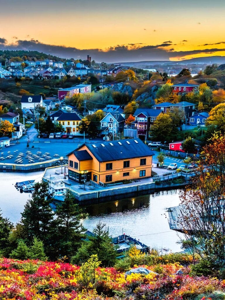 An elevated sunset view of the Quidi Vidi Artisan Studios and the historic fishing village in St. John's, Newfoundland, seen from the Sugarloaf Trail.