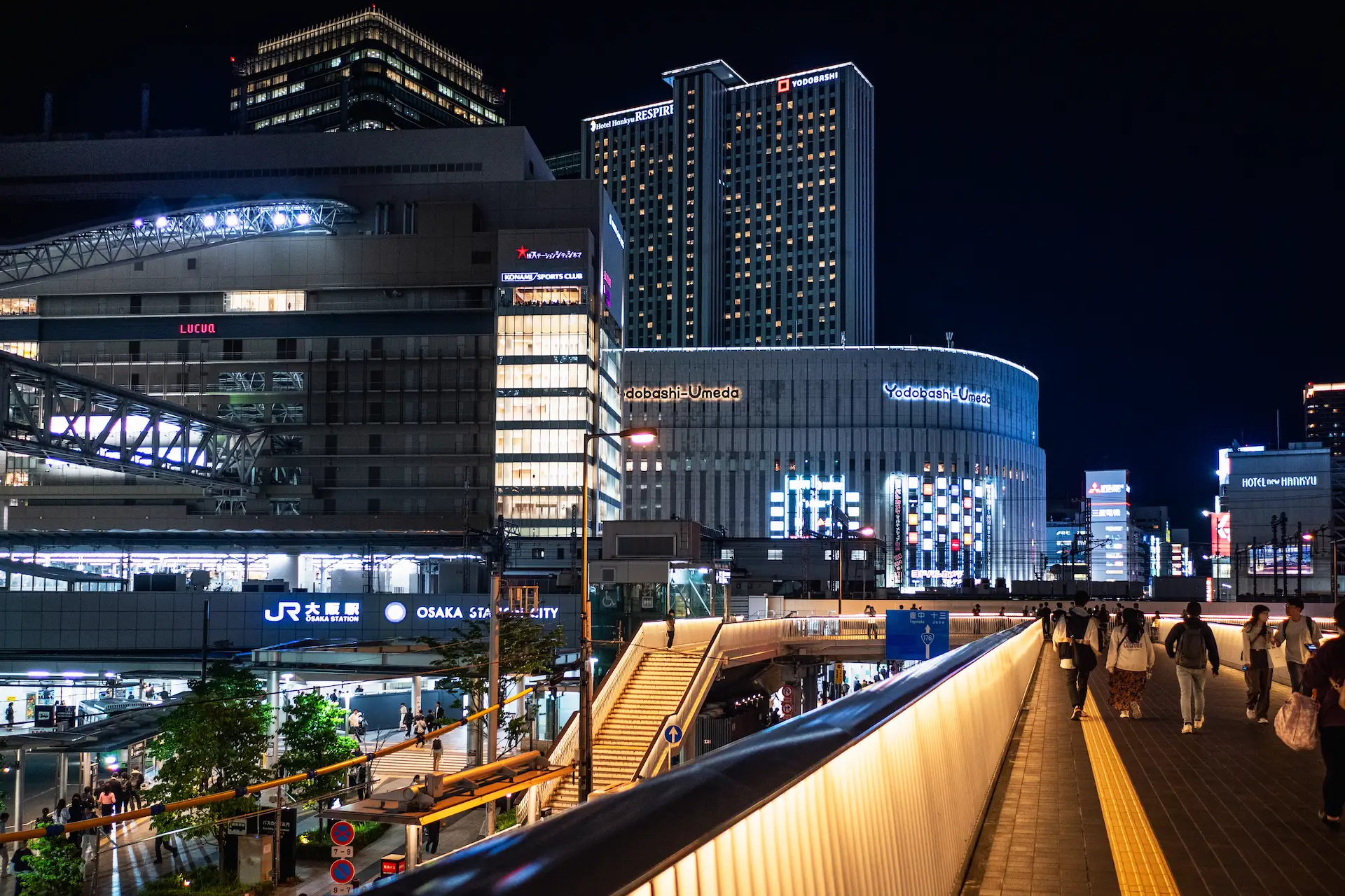 Pedestrian walkway at Osaka Station City illuminated at night with the Yodobashi-Umeda building in the background during a Japan travel itinerary.